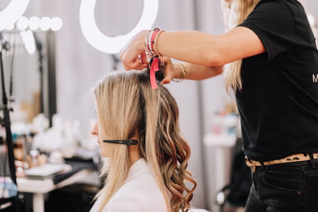 A stylist working on a blonde woman's hair during a studio session in Barcelona, Spain.